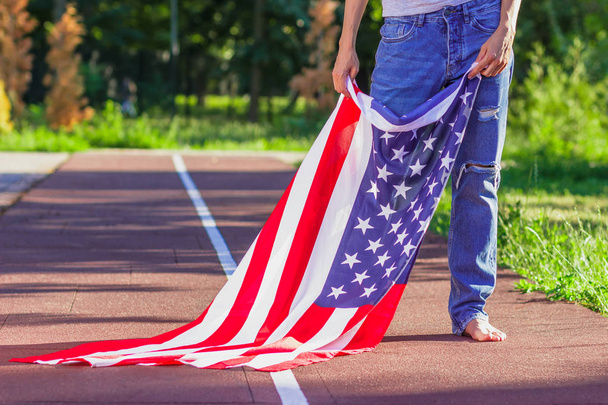 Woman with a flag of United States of America in the hands, outdoors - Photo, image
