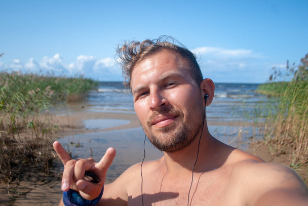 Grappig vent neemt selfie op Ladoga Lake Beach, - Foto, afbeelding