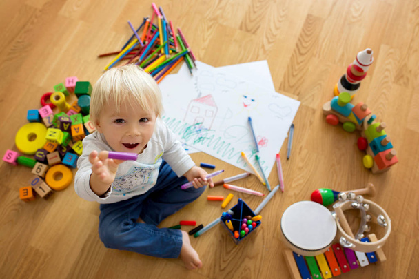 小さなブロンドの幼児の男の子、パステルと着色ペンで描く - 写真・画像