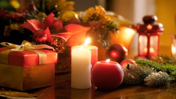 Primer plano 4k video de velas encendidas y decoraciones tradicionales de Navidad en la mesa en la sala de estar. Perfecto para celebraciones de invierno y días festivos
 - Metraje, vídeo