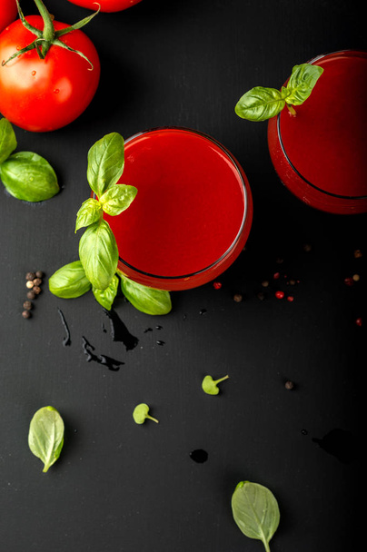 Tomato fresh juice with basil and cherry tomatoes on a black background. Top view. - Fotó, kép