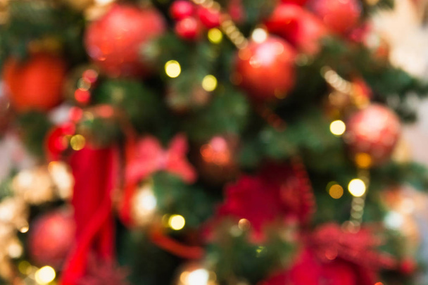 Blurred Christmas tree with golden garland and red balls. Abstract pattern. Xmas. - Фото, изображение