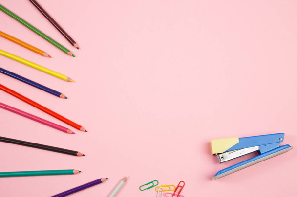 lápices de colores y papelería sobre fondo rosa aislado. arriba
  - Foto, Imagen