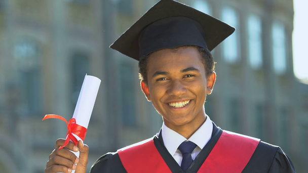 Estudante adolescente afro-americano feliz em terno segurando diploma, educação moderna
 - Filmagem, Vídeo