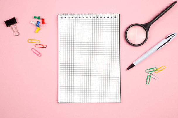 stationery, paper notebook with pen and magnifier on pink isolat - 写真・画像