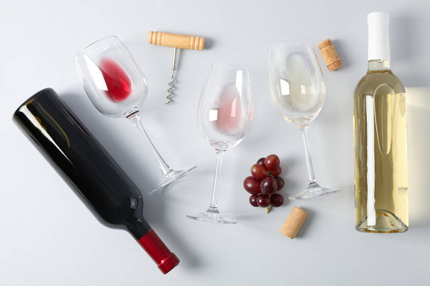 Deitado. Uvas, saca-rolhas, garrafas e copos com vinho no gr
 - Foto, Imagem