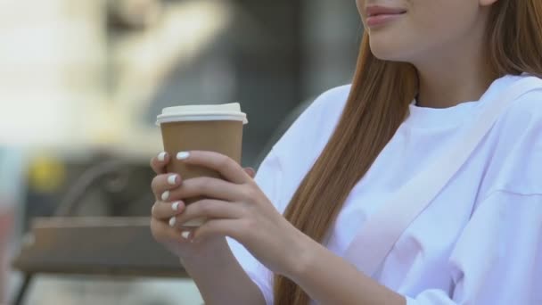Young woman burning lips while drinking hot tea outdoors, take away fast food - Filmagem, Vídeo