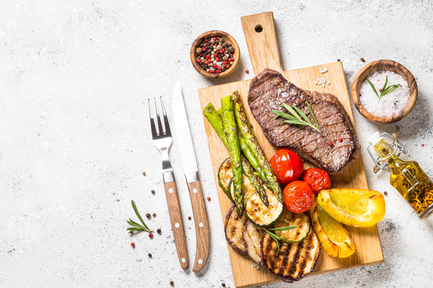 Steak de boeuf grillé aux légumes sur table en pierre blanche
. - Photo, image