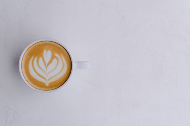 A great coffee latte art in white cup on light background. - 写真・画像