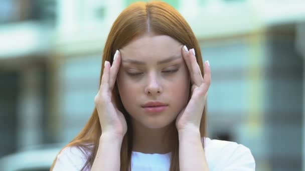 Red-haired young woman suffering migraine massaging temples, health care, ache - Filmagem, Vídeo