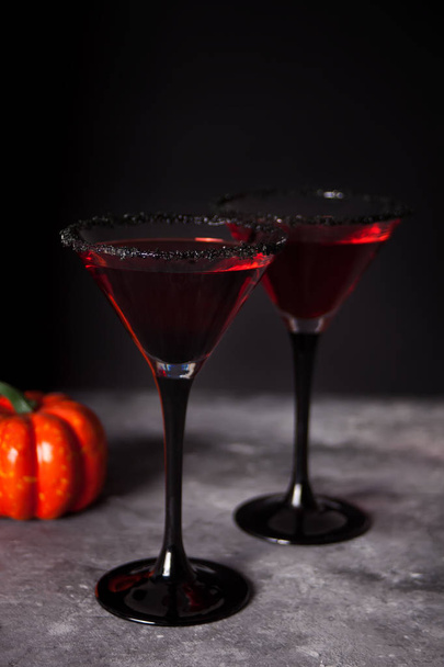 Two glasses with red cocktail for Halloween party on the dark background - Фото, изображение