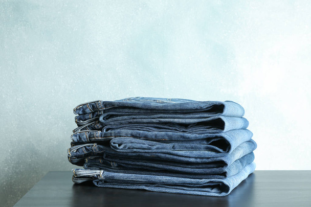 Pila di pantaloni jeans su tavolo nero, spazio per testo
 - Foto, immagini