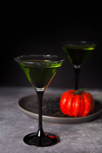 Two glasses with green zombie cocktail for Halloween party on the dark background - Фото, зображення