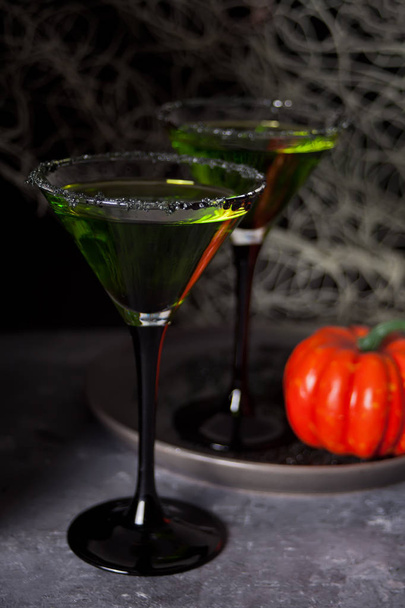 Two glasses with green zombie cocktail for Halloween party on the dark background - Photo, image