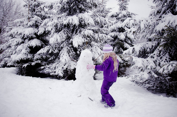 dítě a sněhulák v bílém zimním lese - Fotografie, Obrázek