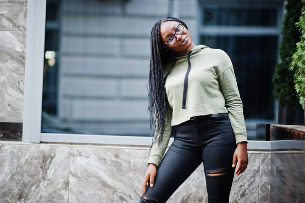 City portrait of positive young dark skinned female wearing gree - Foto, afbeelding