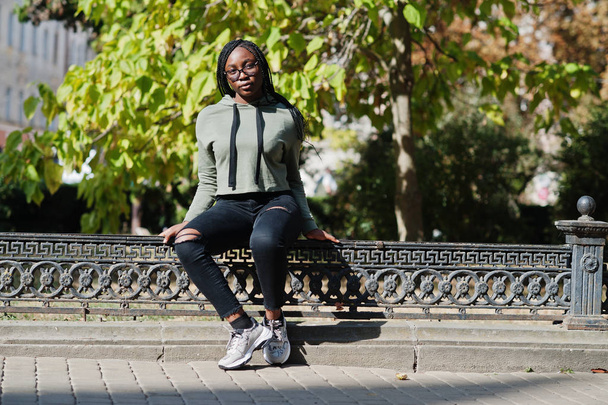 City portrait of positive young dark skinned female wearing gree - Foto, imagen