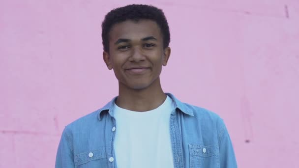 Cheerful African-American male teenager smiling at camera, positive mood - Πλάνα, βίντεο