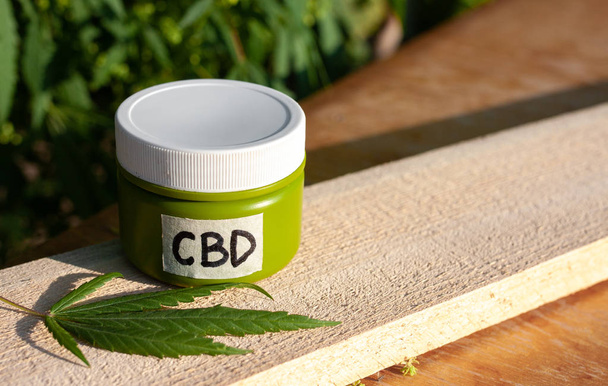 Hemp CBD cream, medical marijuana and cream in jar, legal light  - Foto, afbeelding
