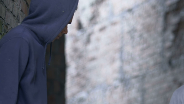 Hooded Afro-American teen criminal chasing boy, risk of robbery, street life - Video, Çekim