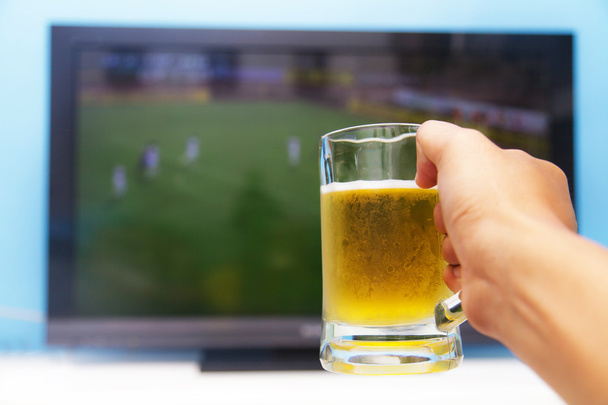 Disfrutando de su cerveza frente a la televisión
 - Foto, Imagen
