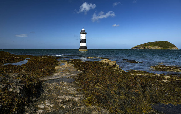 Penmon Lighthouse. Looking out at Penmon lighthouse along the We - Photo, Image