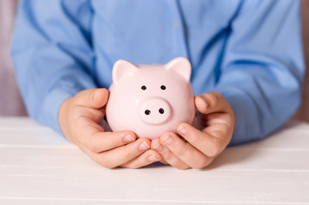 A man holds a piggy bank in his hands. Family savings. - Φωτογραφία, εικόνα