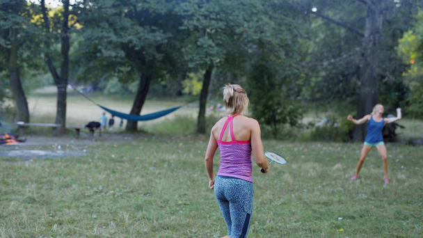 Melko urheilullinen kunto Tytöt pelaavat sulkapalloa puistossa
 - Materiaali, video