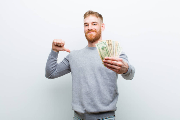 young red head man with dollars against white background - Fotó, kép