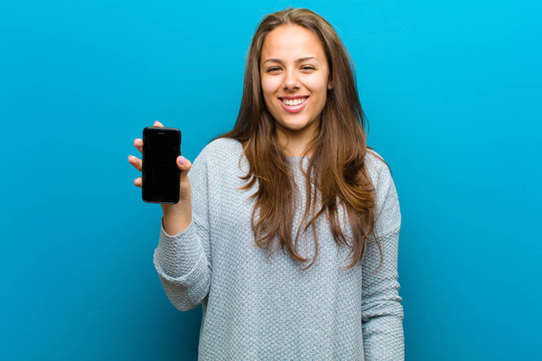 young woman with a mobile phone against blue background - Foto, immagini