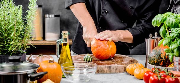 partial view of male chef preparing fresh healthy pumpkins in kitchen - Zdjęcie, obraz
