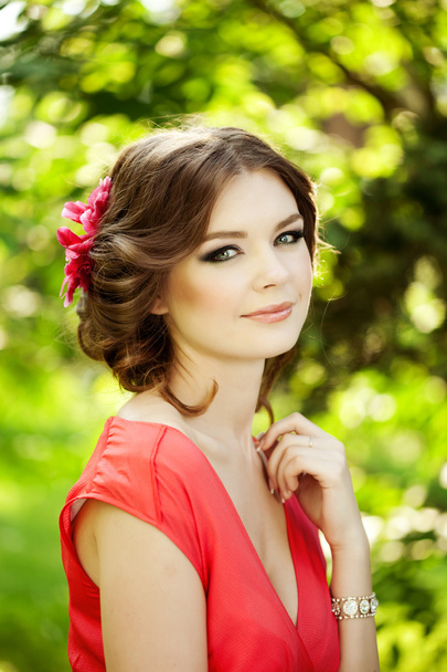 Beautiful woman with a flower in the hairstyle - Foto, afbeelding