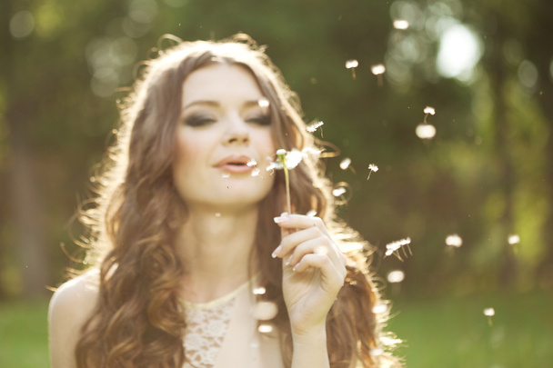 Beautiful woman blowing a dandelion - Zdjęcie, obraz