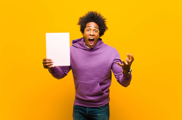 young african american man  against orange background - Foto, imagen