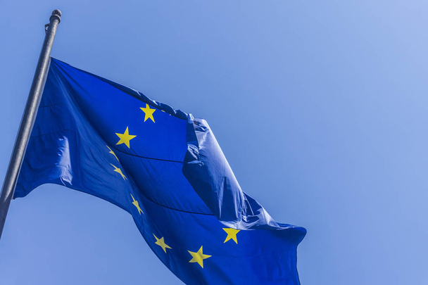European union flag flying against a blue sky background - Foto, afbeelding
