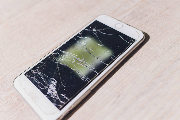 Closeup of severley cracked smashed smart phone. - 写真・画像