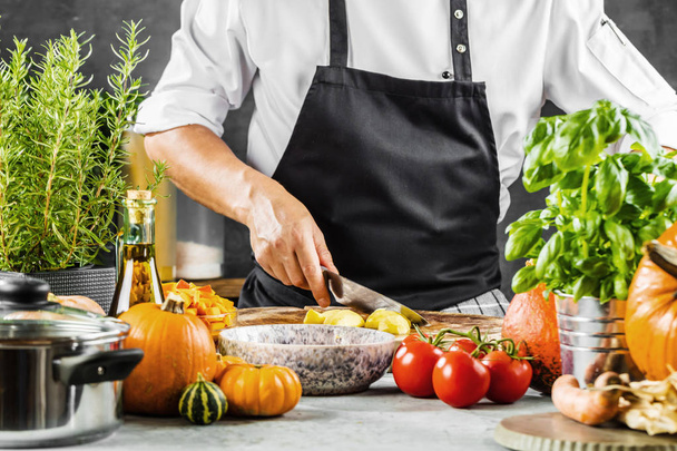 cropped shot of male chef chopping vegetables in kitchen - Photo, Image