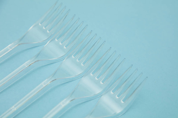 Plastic cutlery forks arranged on a blue background. Plastic was - Foto, afbeelding