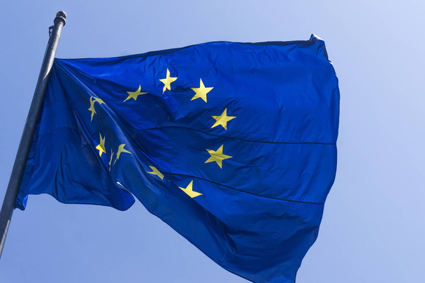 Bandera de la Unión Europea ondeando sobre un fondo azul
 - Foto, Imagen