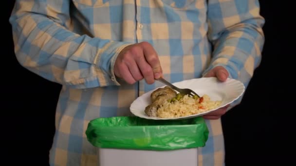 Škrábavý muž s talířem kuřecí stehno, rýže, zelený hrášek do popelnice - Záběry, video