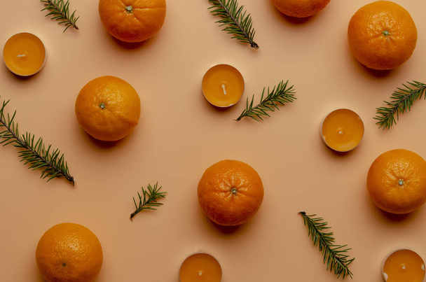 tangerines and candles on peach background. New year concept. - Fotografie, Obrázek