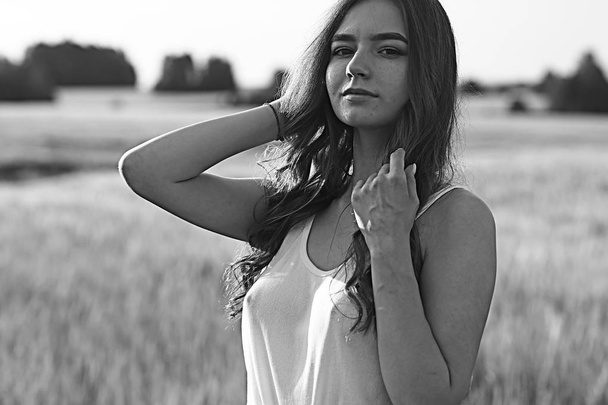 sexy girl in a t-shirt in a field / summer look, a beautiful young adult sexy model - Zdjęcie, obraz