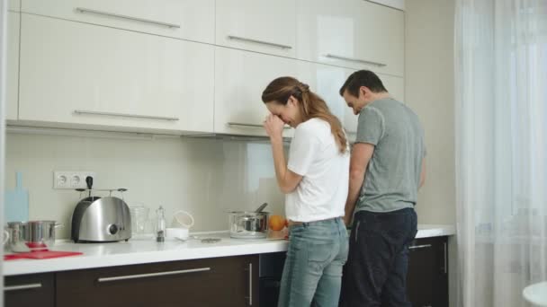 Счастливая пара готовит вместе дома. Мужчина и женщина веселятся на кухне
. - Кадры, видео