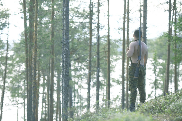 man goes hunting forest summer / landscape in the forest, huntsman with a hunting rifle hunts - Foto, Imagen