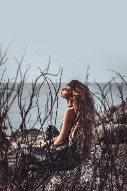 retrato de bela jovem mulher através de galhos secos ao ar livre
  - Foto, Imagem