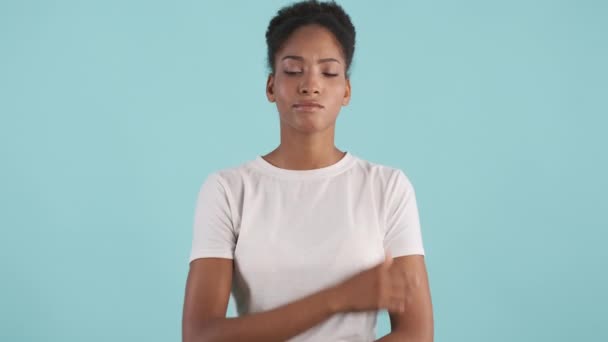 Portrait of thoughtful african american girl thinking and showing no gesture over blue background - Footage, Video