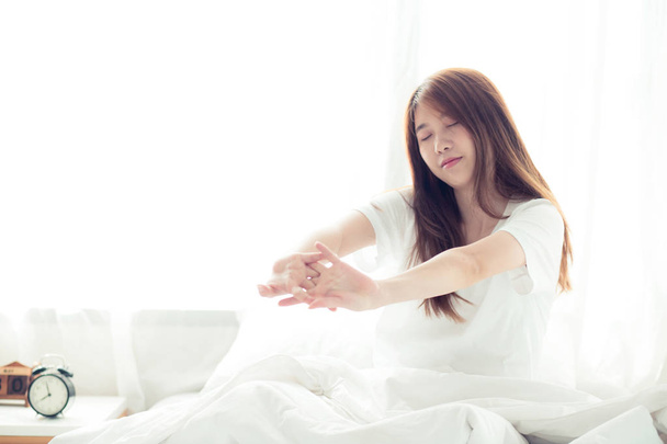 Belle jeune femme asiatique étirer et se détendre au lit après le réveil
  - Photo, image