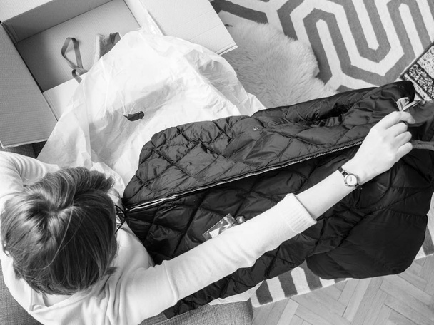 Mulher unboxing desembalar novas roupas de inverno parka
 - Foto, Imagem