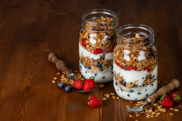 homemade granola with berries in glass jars - 写真・画像