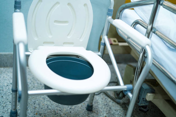 Крісло-комод або мобільний туалет може рухатися в спальні або скрізь для літніх людей з обмеженими можливостями або пацієнта: здорове сильне медичне поняття
 - Фото, зображення